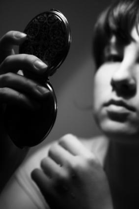 Woman checking her appearance; copyright Andreygorlov at Dreamstime.com