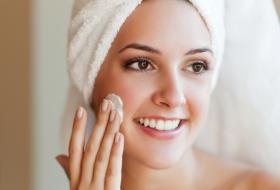 woman applying face cream towel