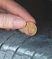 penny checking tire tread