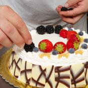decorating a cake with fruit