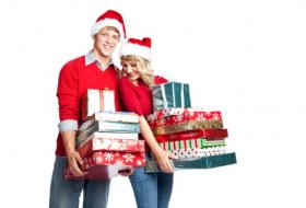 Couple holding stacks of Christmas gifts