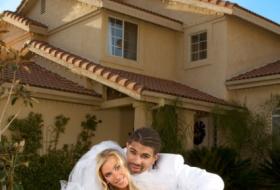 couple posing by house