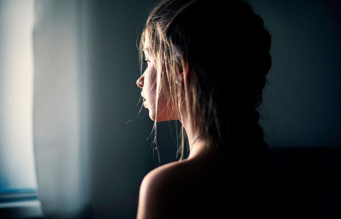 teenage girl looking out window