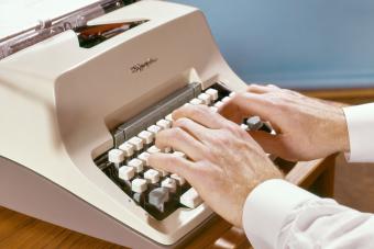 Man writing on Olympia Manual Typewriter