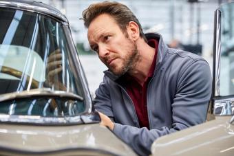 Male engineer examining vintage car in industry