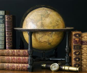 Old fashioned globe and books on table