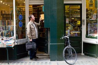 man looking at rare books in bookstore