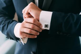 man hands puts on cufflinks