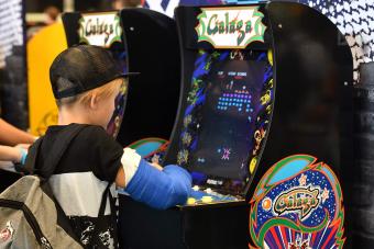 A boy plays the Galaga arcade game during the video games trade fair Gamescom in Cologne, western Germany