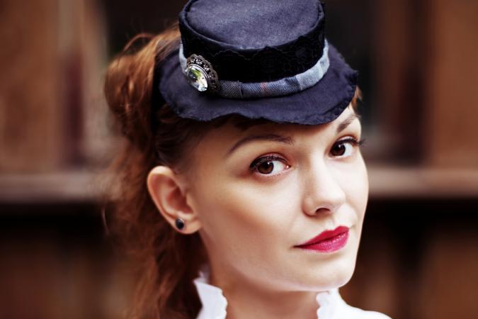 Beautiful red hair woman in vintage clothes and hat with hatpin