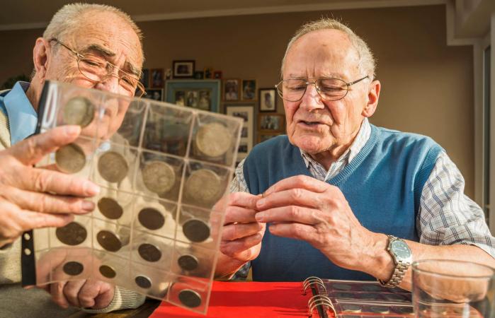 Two senior friends with coin album