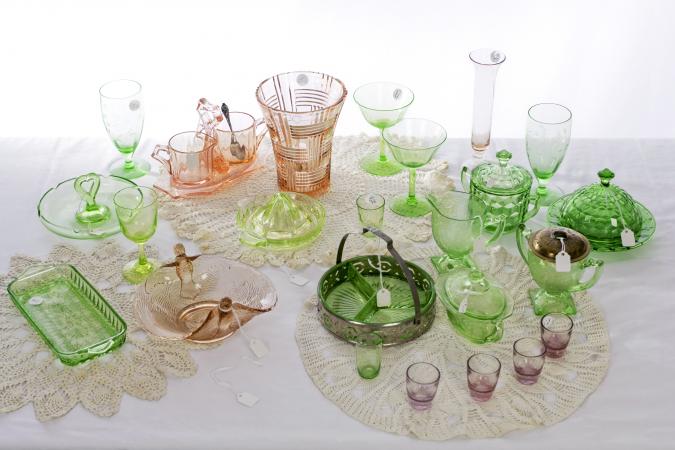 A table with a variety of pink and green American Depression glass