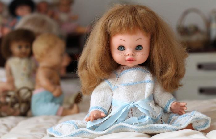 Vintage doll sitting in bed