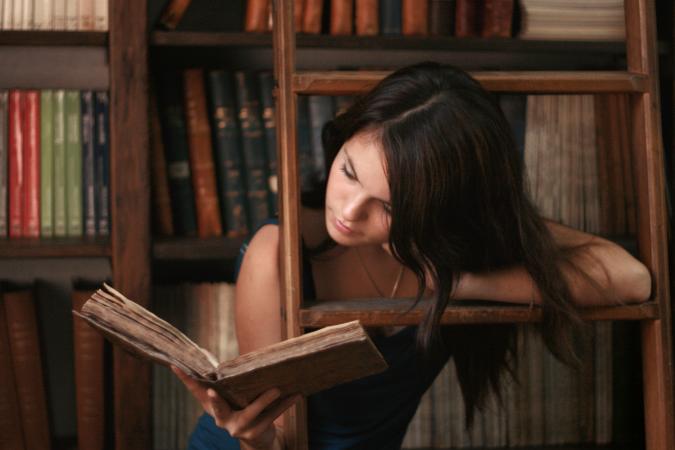 Young woman reading at antique library