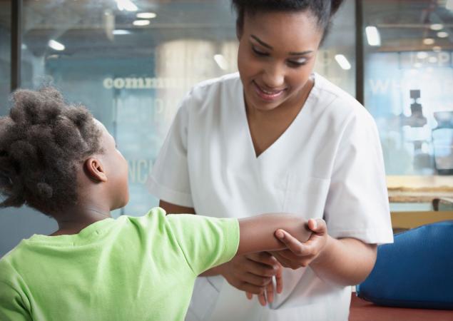 Therapist bending arm of girl