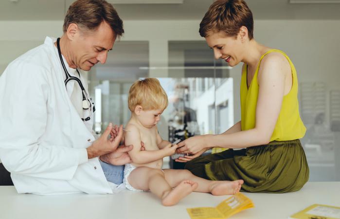 Pediatrician vaccinating toddler