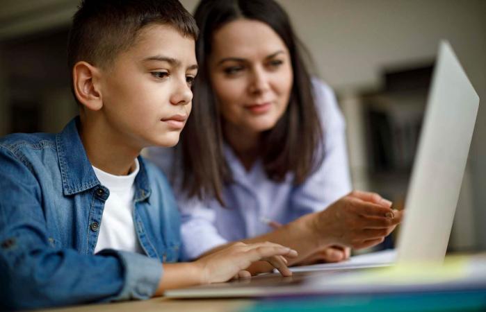 Mother an son using laptop at home