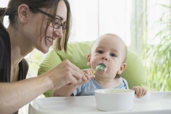 Mother feeding baby in high chair