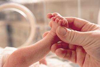 Small premature baby lies in an incubator