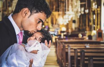 Man Kissing Baby Girl On Forehead In Church