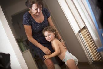 Toddle in diapers with grandma playing at home