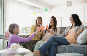 Female friends toasting drinks at baby shower