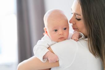 a mother carrying her baby at home