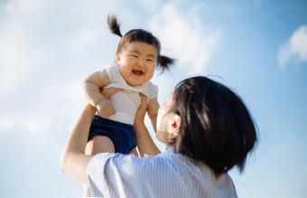 Women lifting up baby girl