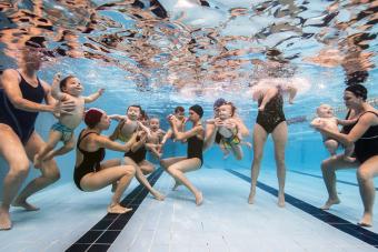 Infants getting used to water in swimming pool