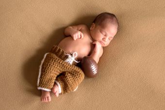 Newborn baby wearing football uniform