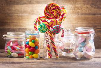 Colorful candies, jellies, lollipops, marshmallows and marmalade in a glass jars