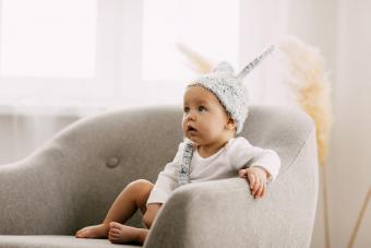 Cute Boy Looking Away While Sitting At Home