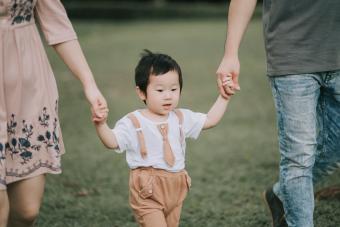 family with their son holding hands
