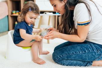 mother reading book to child learning potty training