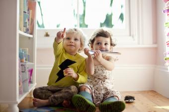 Female and male toddler friends pointing and looking up