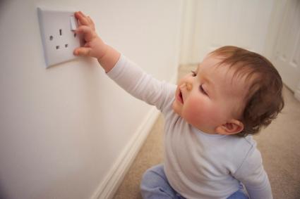 Toddler playing with plug socket