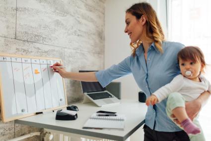 Woman holding baby filling out schedule