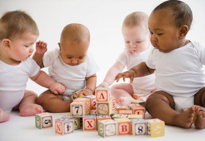 Four babies playing with blocks
