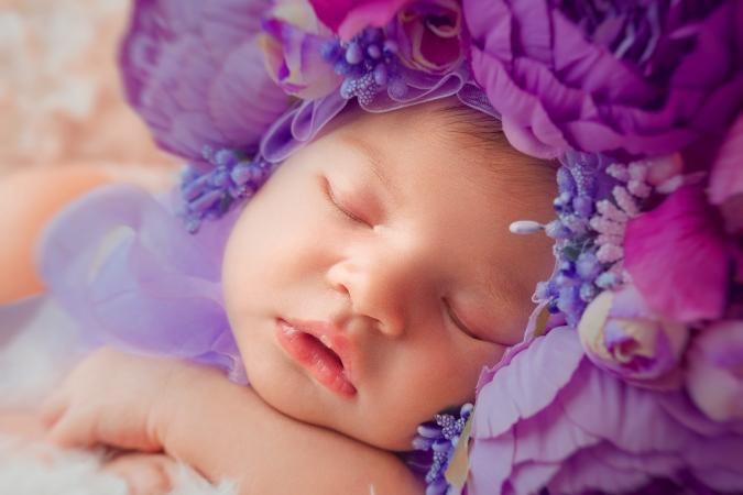 Sleeping newborn baby girl in flower wreath