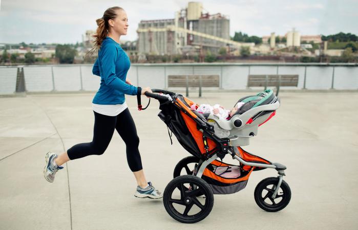 Woman pushing baby stroller while jogging