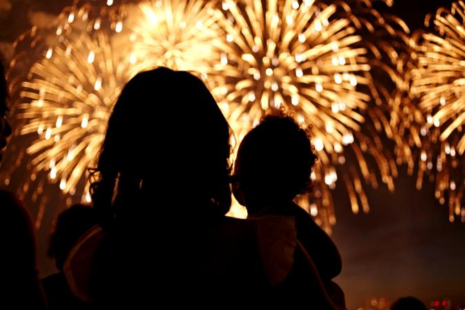 Silhouette of mother and daughter watching fireworks