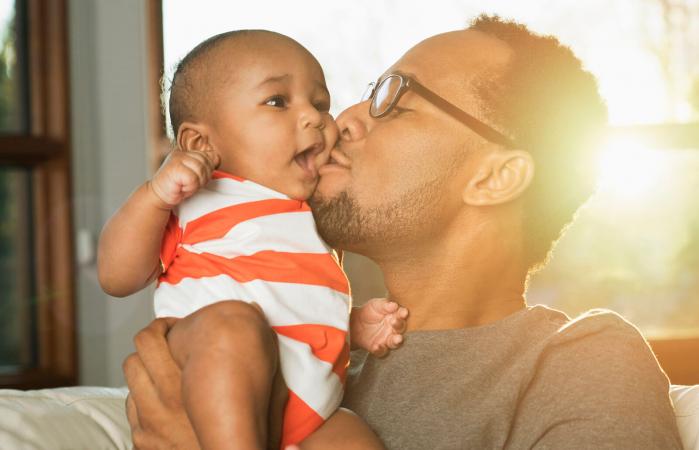 father kissing baby son on cheek
