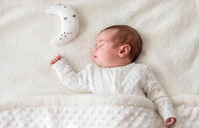 Baby boy in bed sleeping with moon