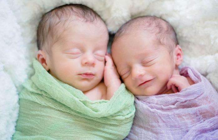 Newborn twins sleeping peacefully together