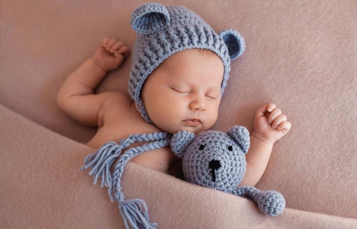 Baby boy lying on bed