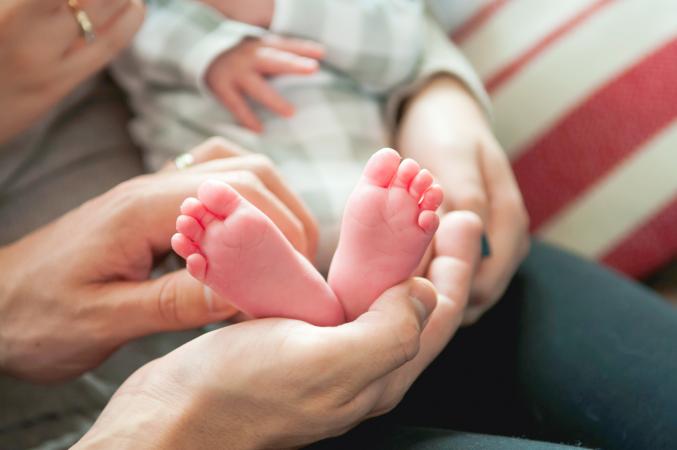 Baby feet held up by dad's hands