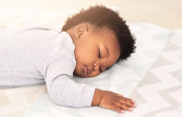 little baby boy sleeping on a bed