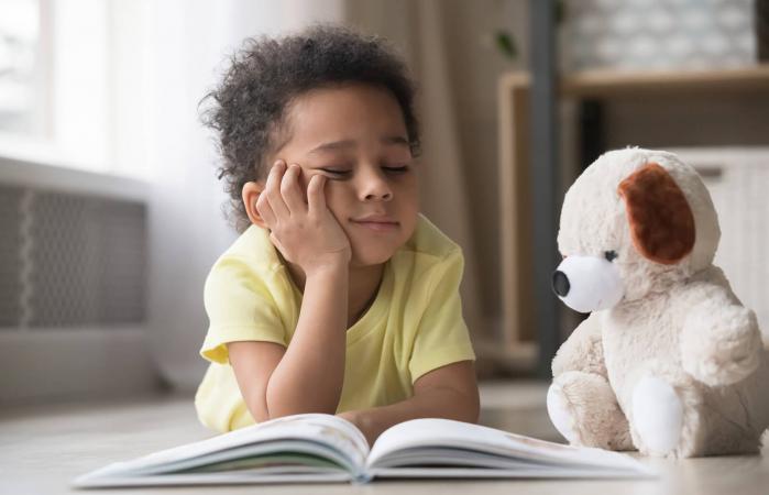 Bored little boy reading book