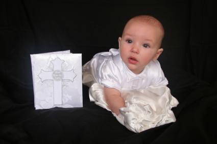 Baby in baptism gown with baptism book