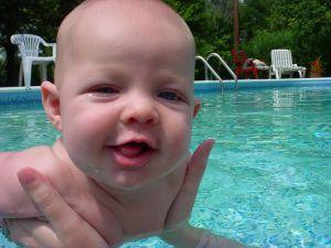 Parent holding an infant in a swimming pool